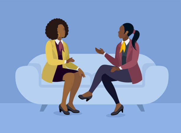 Two women talking and sitting on a sofa - DR KATERINA GEORGIADIS